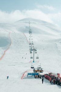 People Riding Cable Cars over Snow Covered Mountain