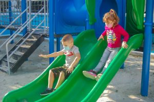 a couple of kids that are on a slide