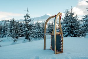 brown wooden snow sled on snow covered ground during daytime